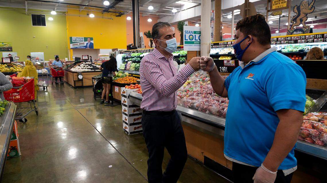 Sean Loloee, a candidate for Sacramento City Council District 2, fist bumps produce manager Miguel Vaca at Viva Supermarket in Sacramento’s Del Paso Heights neighorhood in 2020.