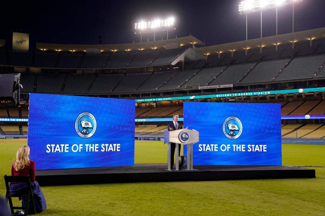 California Gov. Gavin Newsom delivers his State of the State address from Dodger Stadium as his wife Jennifer Siebel Newsom listens Tuesday in Los Angeles.