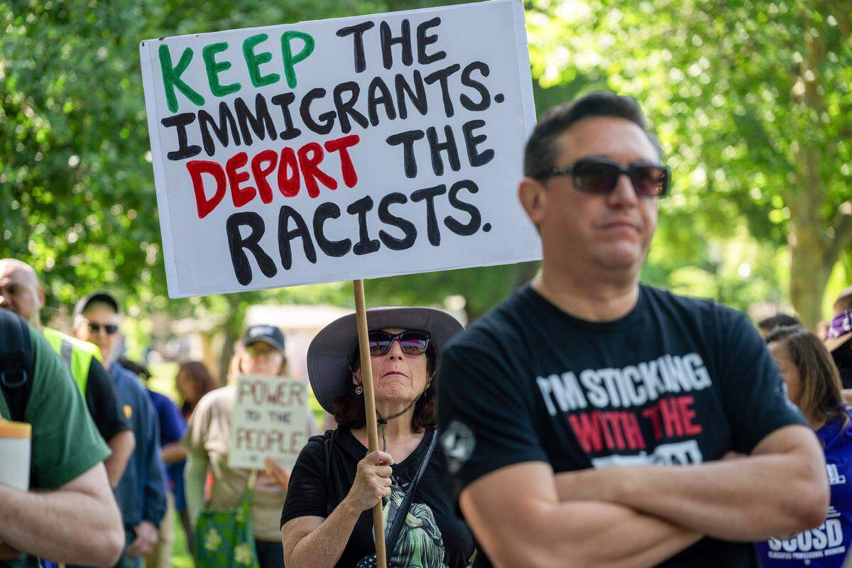 Maurya Perazzo of Sacramento holds a sign at Southside Park in Sacramento as she joins hundreds participating in the “A Day Without Immigrants” 20th anniversary march on Friday.