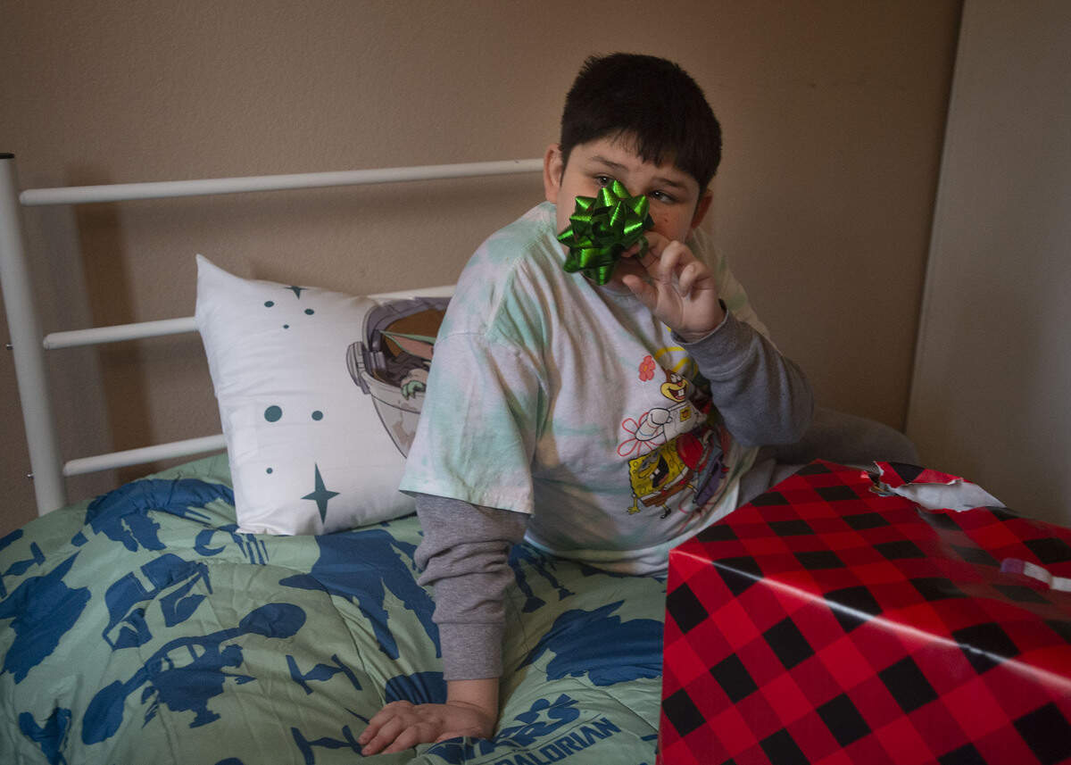 While sitting on his new bed, Victor Ehle Jr., 10, plays with a ribbon off a gift from the North State Building Industry Foundation on Monday in South Natomas. The organization hopes the Book of Dreams readers will help raise $3,300 to purchase more beds for the foundation’s Out of School Youth work readiness program, Project My Own Bed.