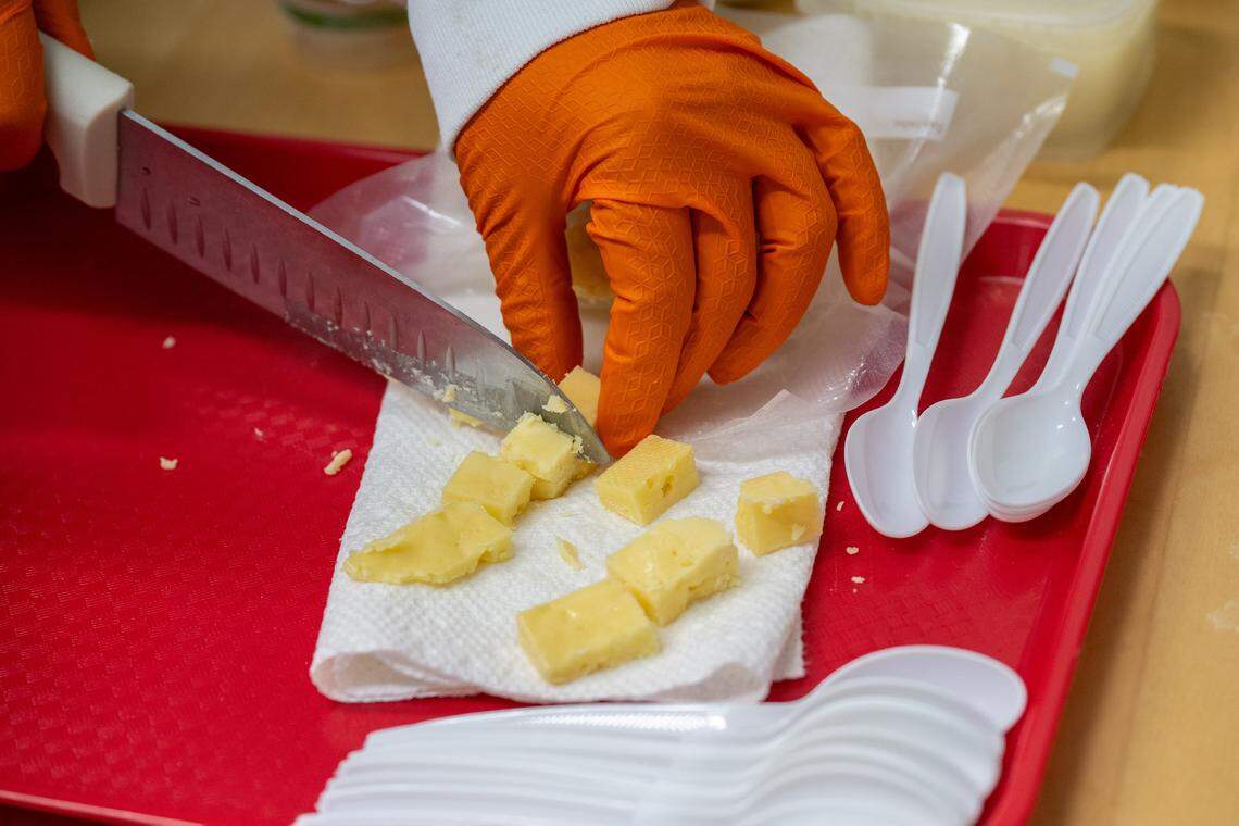 Abhinav Anand, founder of JUST Creamery, cuts pieces of gouda cheese for tasting at the production facility on Wednesday, Feb. 18, 2026, in Wilton. Abhinav said the cheeses are farm-to-table fresh, made the traditional way in small batches and with zero preservatives, just like homemade. 