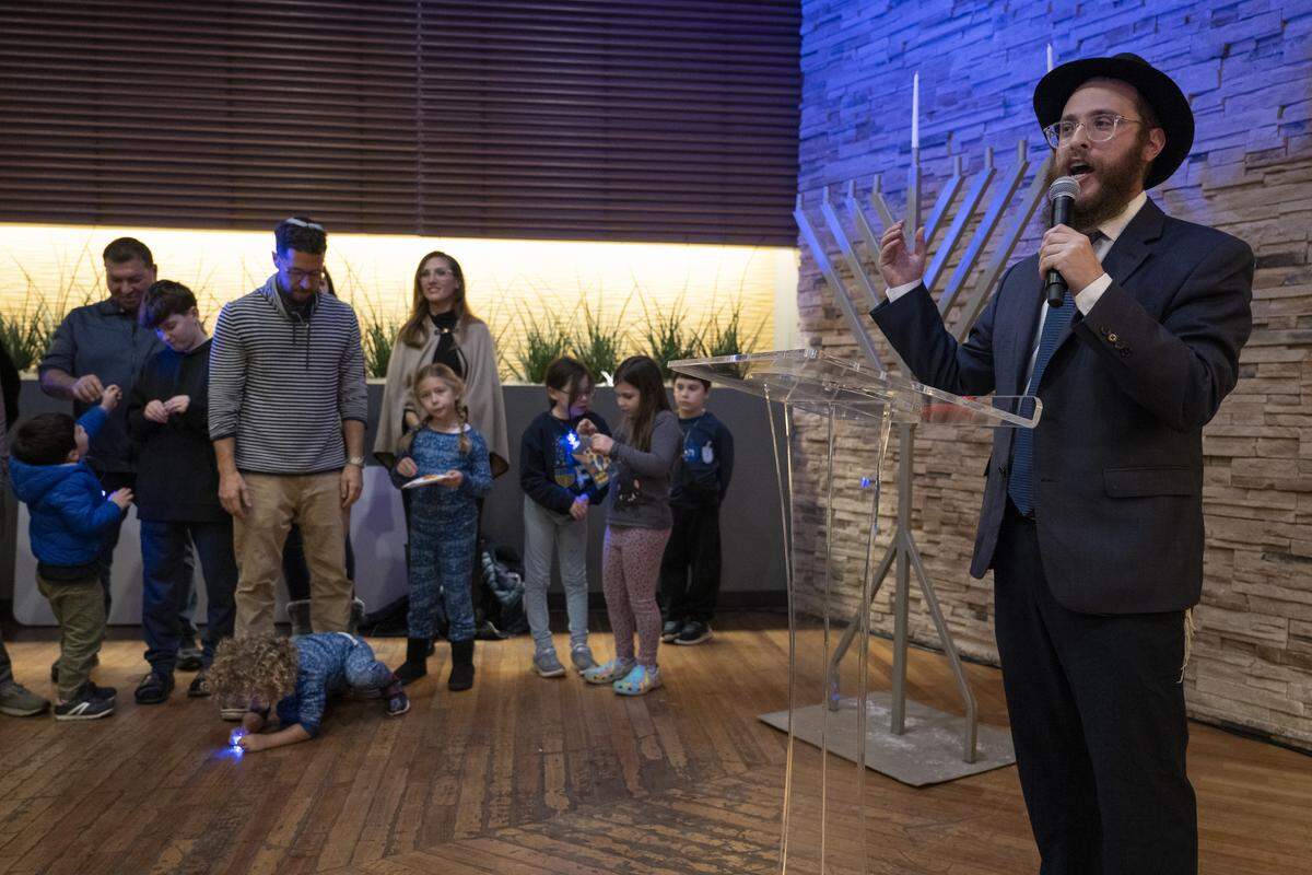 Rabbi Yossi Korik, the executive director of Chabad of Placer County, hosts a menorah lighting on the first night of Hanukkah at the Westfield Galleria in Roseville on Sunday.