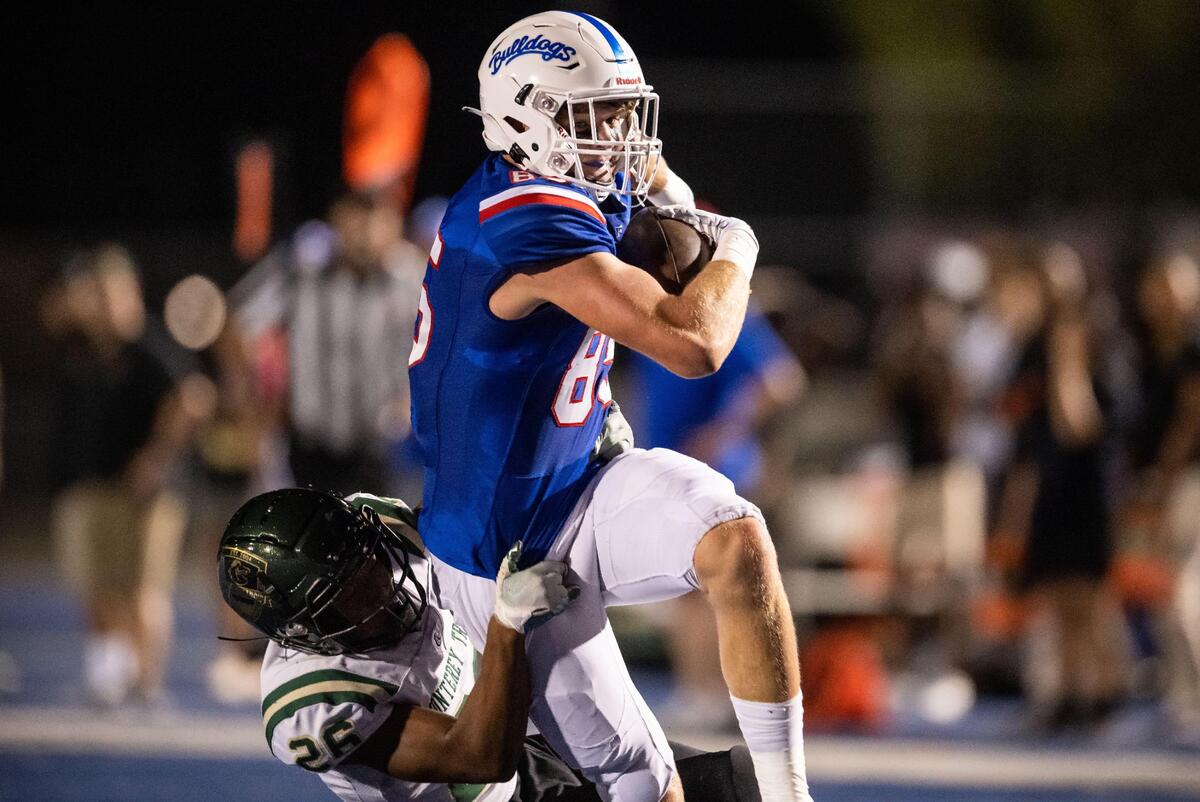 Folsom High School tight end Walker Lyons (85) is tackled by Monterey Trail High School defensive back Vontrelle Waffer (26) after a reception in the first quarter of their high school football opening night game Friday, Aug. 19, 2022, at Folsom High School. Lyons broke his leg on the play.