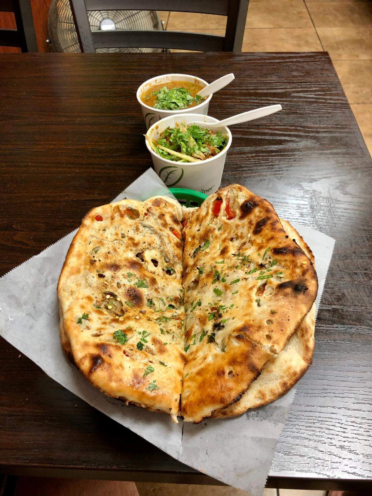 Kabab Hut customers can use aloo paratha, seen in the foreground, to scoop up dishes such as Lahori chikar chole and chicken karahi.