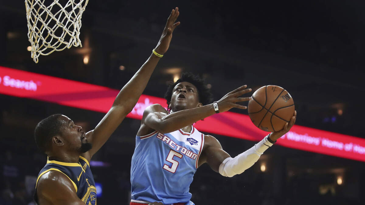 Kings guard De’Aaron Fox (5) goes to the basket against Golden State Warriors forward Kevin Durant on Nov. 24 in Oakland. The teams meet Friday in Sacramento.