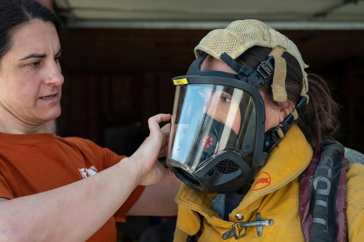 Megan Albrecht of the Waterloo Morada Fire District helps Kailynn Munoz, 17, put on her mask before the search and rescue station on Sunday. “At first it was scary,” Munoz said about going through the smoked filled rooms. “Having a person with you made me fill more secure.”