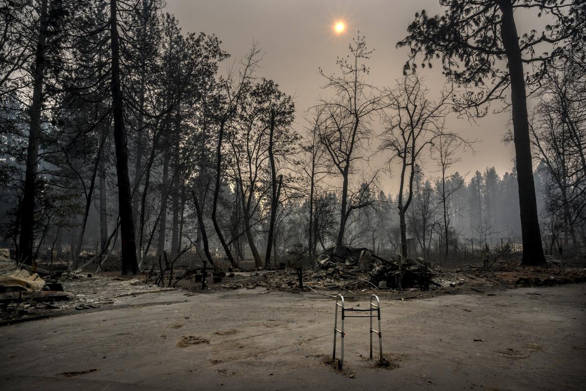 A walker remains on the road in front of mobile homes devastated by the Camp Fire at the Pine Springs Mobile Home Park in Paradise, Thursday Nov. 15, 2018.