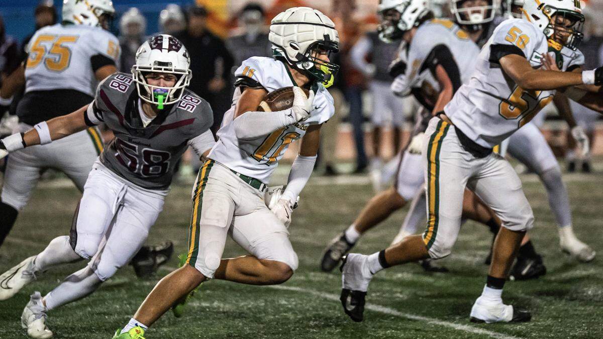 Rio Americano Raiders running back Niko Chatzis (11) carries the ball upfield past Woodcreek Timberwolves defensive end Brody Kee (58) in a CIF Sac-Joaquin Division III semifinal playoff game in Roseville on Friday, Nov. 21, 2025. 