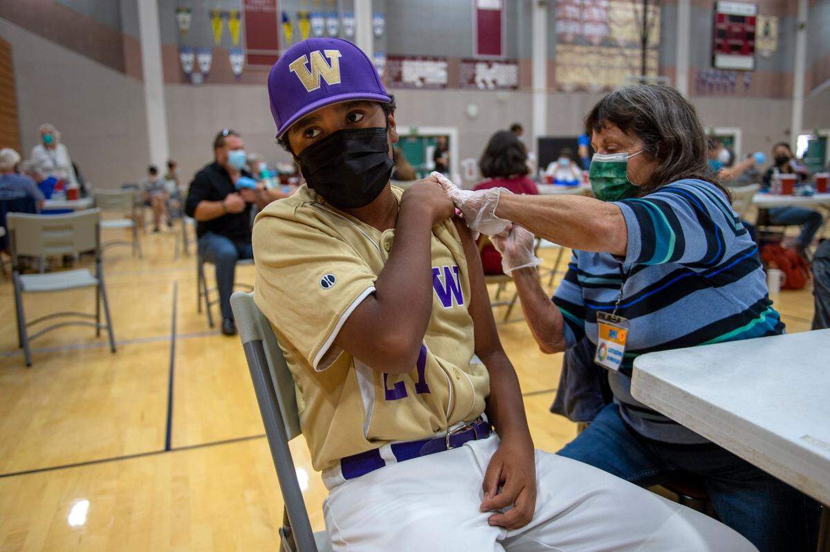 Aidan Gomez, 12, gets a COVID-19 vaccine shot in 2021 at Natomas High School, before a Little League game with the Washington Huskies.