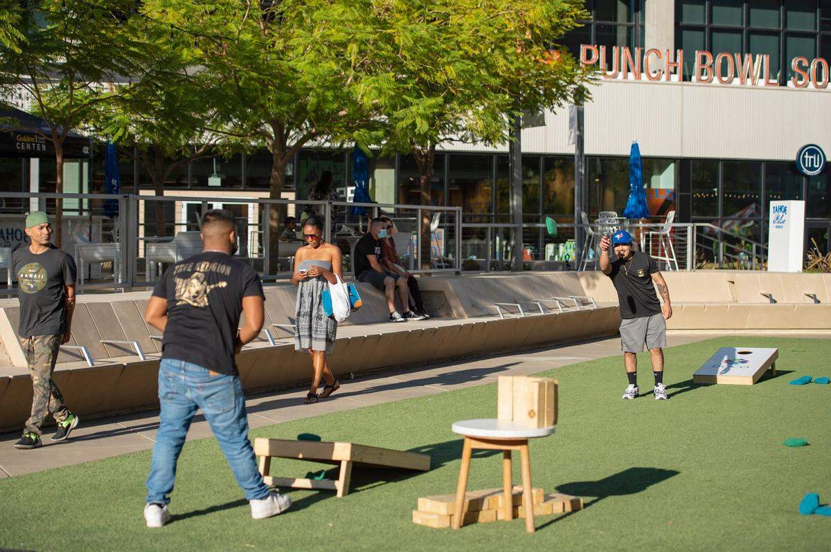 Uriel Franco, left, of Sacramento, and Edgar Sandoval, a Los Angeles native, play cornhole at DoCo in downtown Sacramento on Sunday. The pair wanted to get out of the house and get fresh air, said Sandoval.