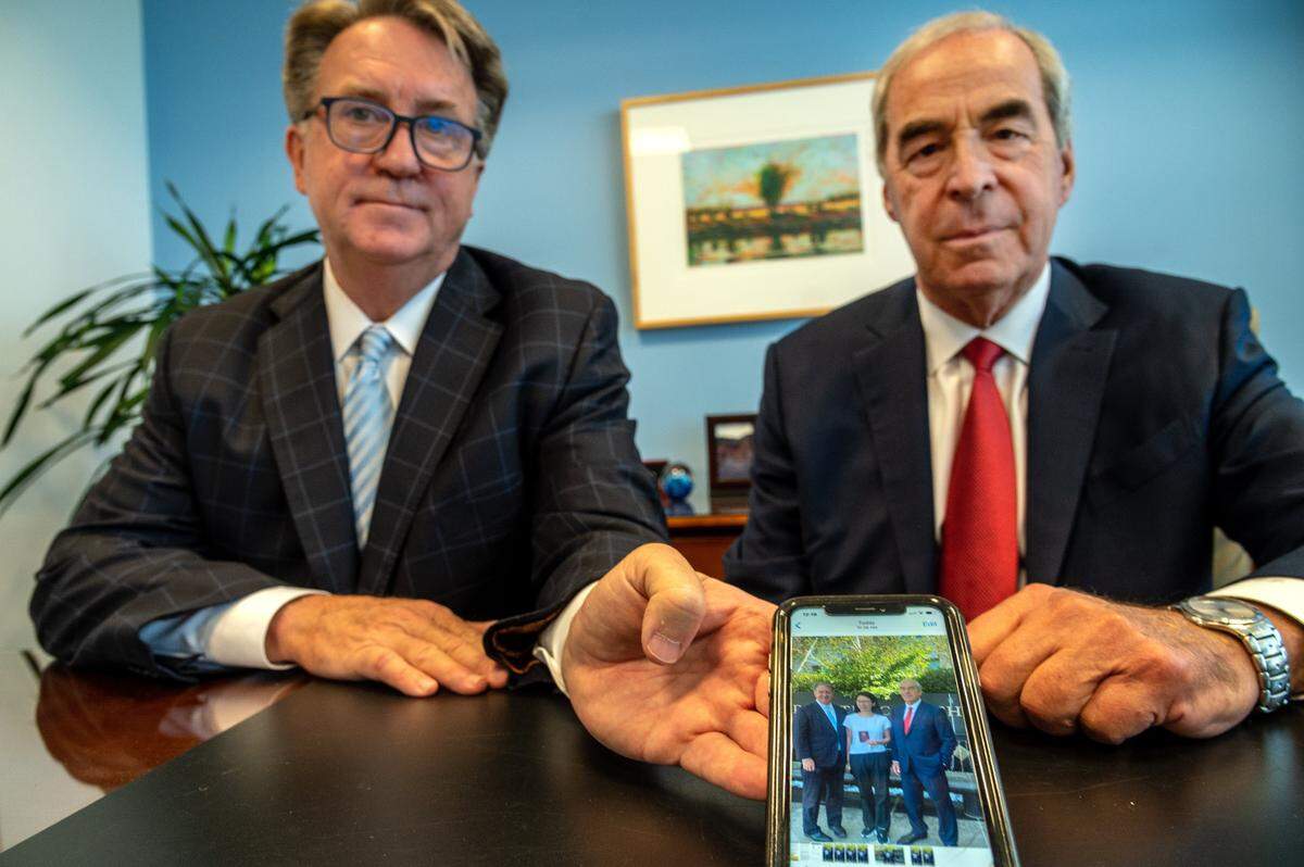 Tom Johnson, left, and Malcolm Segal, attorneys for Juan Tang, the visiting Chinese cancer researcher who was accused of lying about her ties to the army in China, hold a smart phone on Friday, July 23, 2021, showing a photo they took of her earlier in the day with her passport before she left the United States to be with her family in China after her case was dismissed.