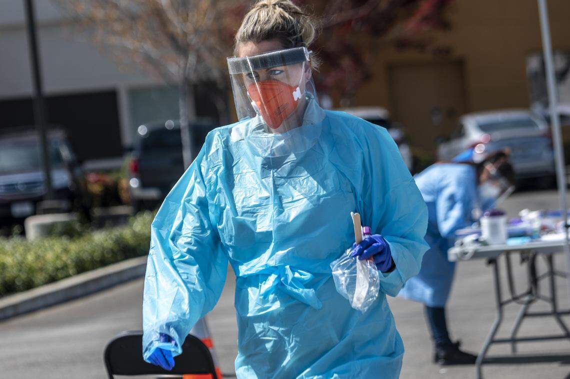 Licensed vocational nurse Ashley Bennett returns to a car where a test has been approved after a screening at Ampla Health’s drive-through coronavirus testing site in Yuba City on Friday, March 27, 2020.