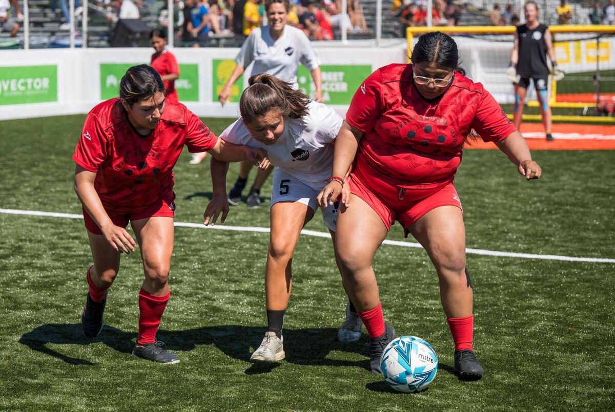 Denmark’s Signe is kept away from the ball by US players Francisca, left, and Jennifer during their women’s match on the final day of play at the Homeless World Cup on Saturday, July 15, 2023, at Hornet Stadium at Sacramento State.