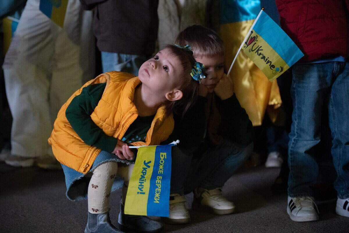 Naomi Shelvchuk, 2, holds a Ukrainian flag at the state Capitol on Monday. She was there with her family to mark the third anniversary of Russia’s invasion of Ukraine.