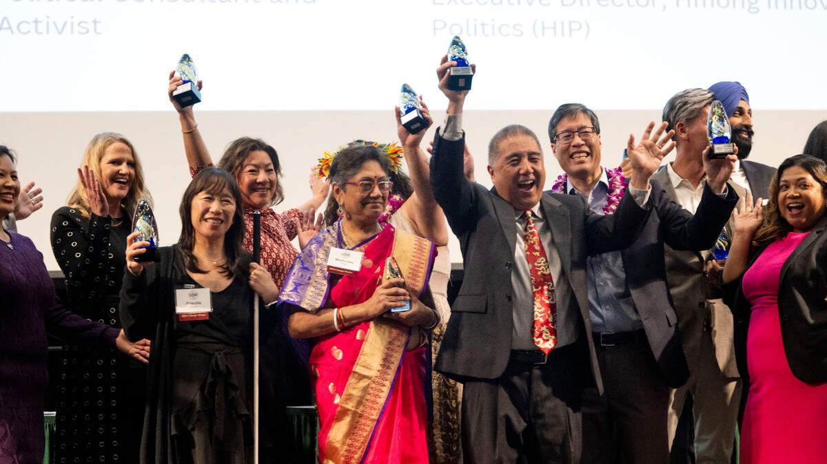 The top 20 Asian American and Pacific Islander Change Makers raise their awards during an event hosted by The Sacramento Bee’s Equity Lab and the Nehemiah Emerging Leadership Program on Friday, March 22, 2024, at Sacramento State.