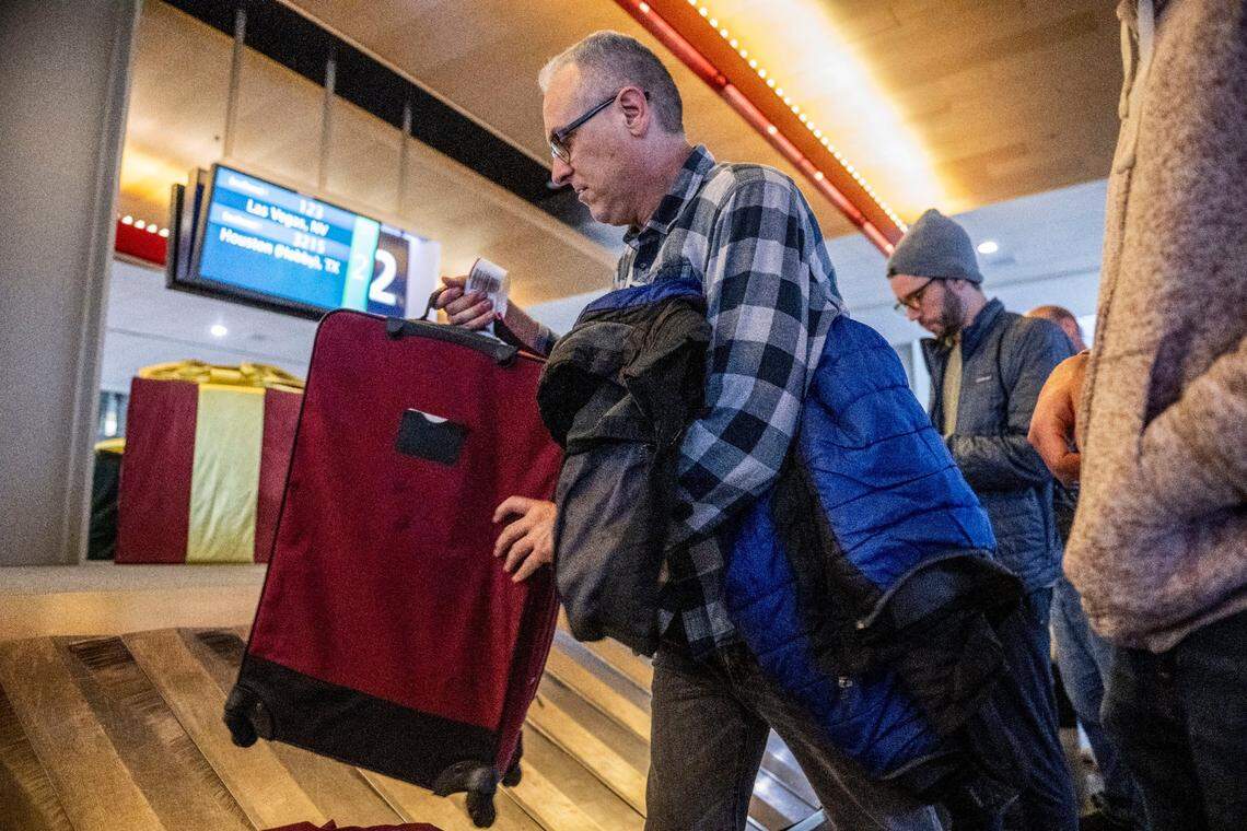 After spending Christmas day and night at the airport in Las Vegas because of a missed connection caused by a four hour delay at his home airport in Chicago, Phillip Scaliatine, picks his luggage up Tuesday at Sacramento International Airport. Wearing the same clothes he had since Sunday, Scaliatine said he and his son Steven slept on the floor at the Las Vegas airport before they could catch a flight to visit his daughter in Sacramento.