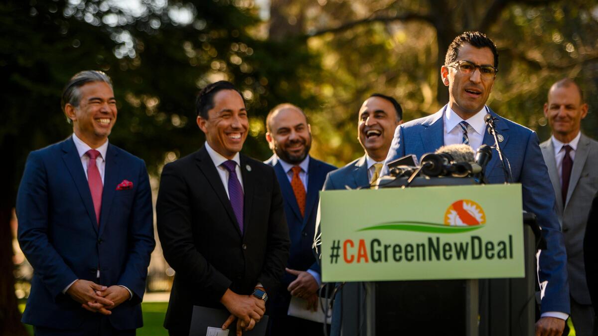 Assemblyman Robert Rivas speaks at the podium as a group of Democratic lawmakers announce the California Green New Deal Act near the east steps of the Capitol in downtown Sacramento, Monday, Jan. 6, 2019.