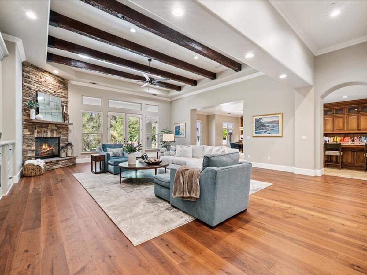 Adjacent to the chef’s kitchen is a large living room that opens out to the pool area.