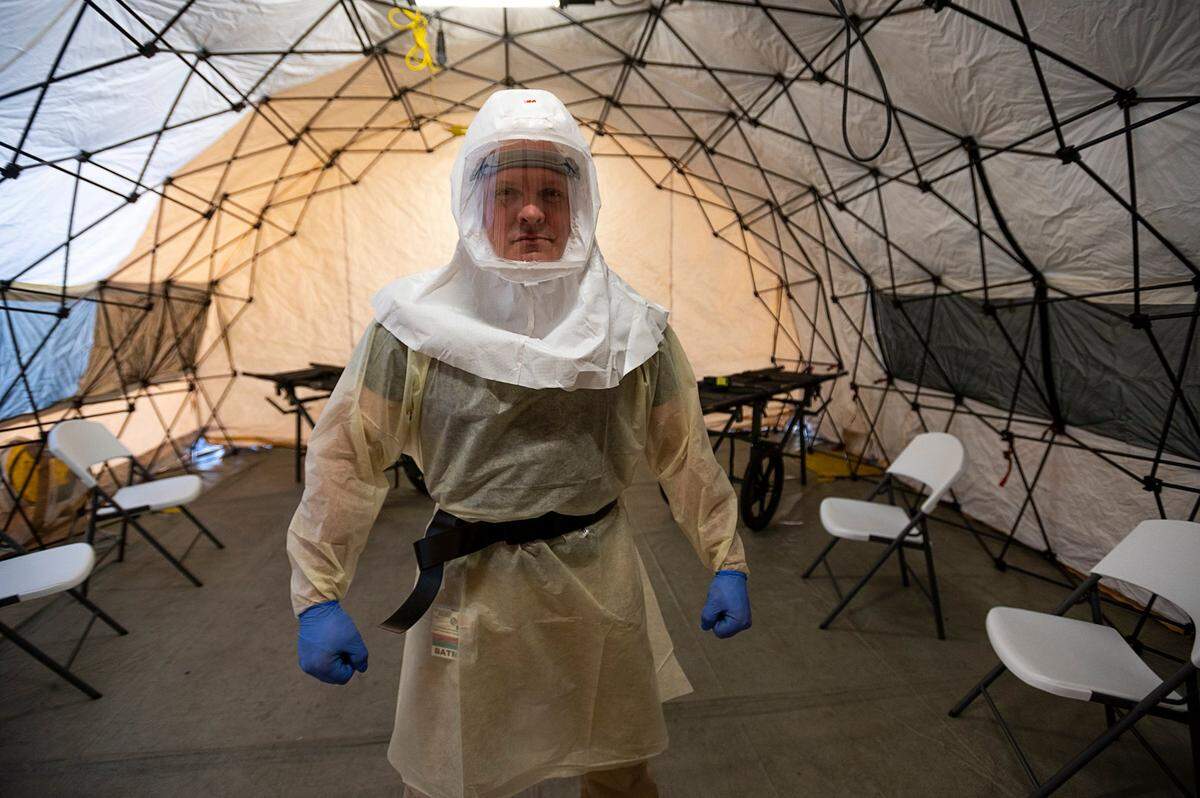 Registered nurse Erin Angle demonstrates the powered air purifying respirator and clothing designed to help support a potential patient surge related to infectious respiratory illnesses, including COVID-19, in a triage tent at the Sutter Roseville Medical Center on Wednesday, March 4, 2020.