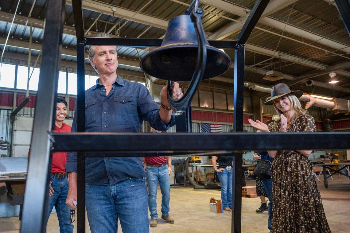 California Gov. Gavin Newsom rings a bell that a student made as First Partner Jennifer Siebel Newsom applauds during a tour of the Agriculture Mechanics building on the University Farm at Chico State on Tuesday, April 22, 2025. The couple participated in an Earth Day celebration at the university.