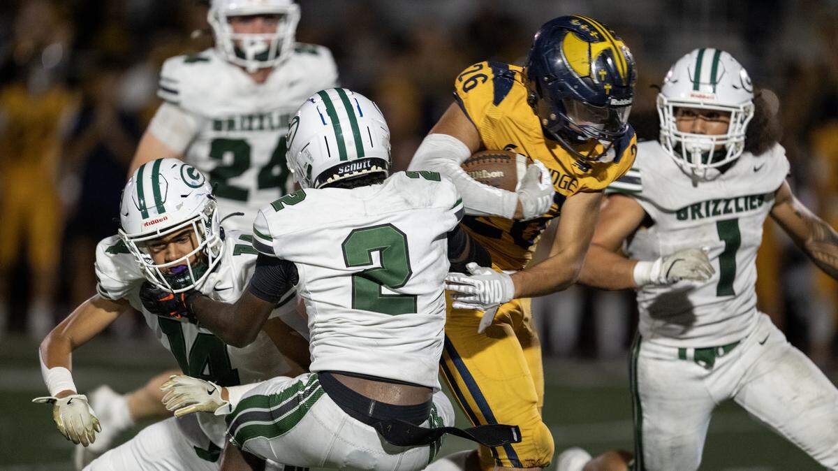 The Oak Ridge Trojans' Tyler Andujar (26) runs past the Granite Bay Grizzlies' Darnell Turner (2) on Sept. 26 in El Dorado Hills. The teams are No. 2 and No. 4 in The Bee’s rankings. 