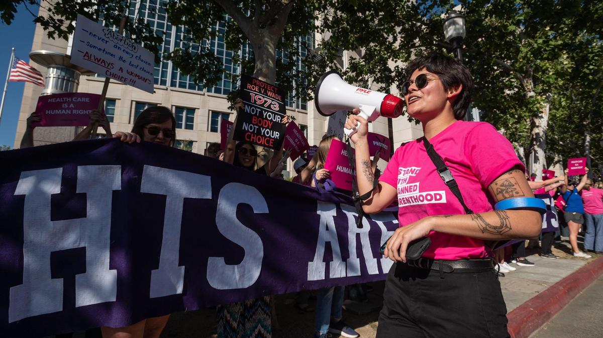 Xenia Vidal, with Planned Parenthood Affiliates of California, leads a chant while walking past a line of protesters gathered outside the federal courthouse in downtown Sacramento on Tuesday, May 3, 2022, in response to news reports that the U.S. Supreme Court is poised to overturn the landmark Roe v. Wade decision protecting the right to abortion.