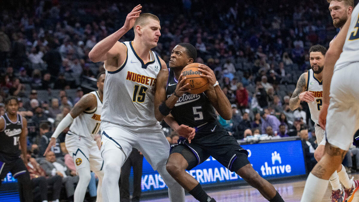 Sacramento Kings guard De’Aaron Fox (5) is guarded by Denver Nuggets center Nikola Jokic (15) during the second half of an NBA basketball game in Sacramento, Calif., Thursday, Feb. 24, 2022. The Nuggets won 128-110. (AP Photo/Randall Benton)