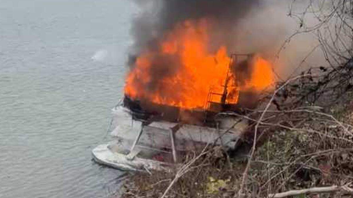 A boat burns Wednesday on the Sacramento River bank near Garden Highway, as firefighters began efforts to put the fire out before it spread to vegetation.