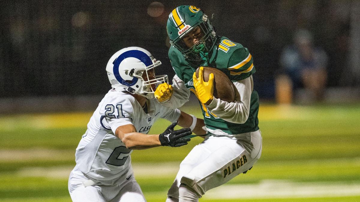 The Placer Hillmen’s Keefer Abs (16) flips around as he is defended by the Casa Roble Rams’ Preston Scott (21) on Friday, Aug. 23, 2024, in Auburn during the season opener for both teams.