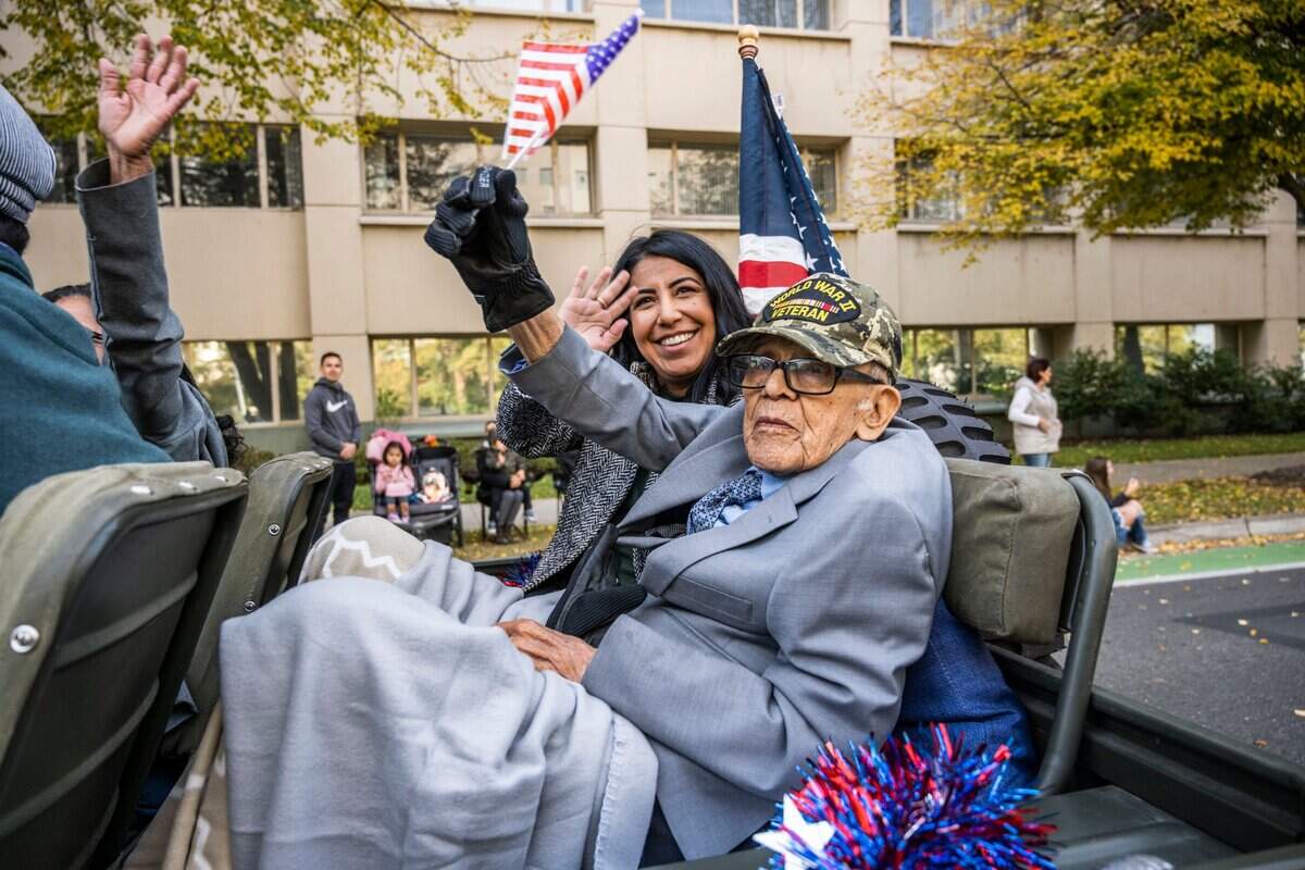 Sacramento WWII Veteran Joe Ortiz, 99 rides with his granddaughter Kimberly Lyons during the Veteran’s Day Parade in Sacramento on Friday, Nov. 11, 2022.
