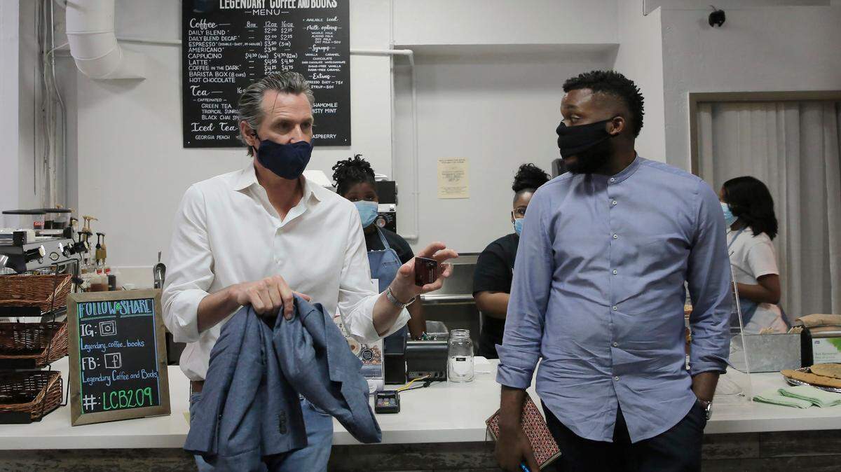 Gov. Gavin Newsom, left, talks with then-Stockton Mayor Michael Tubbs during a stop at Legendary Coffee and Books in Stockton in 2020. Tubbs now works for Newsom on a project to address poverty in the state. His travels brought him to Fresno on Wednesday, July 27.
