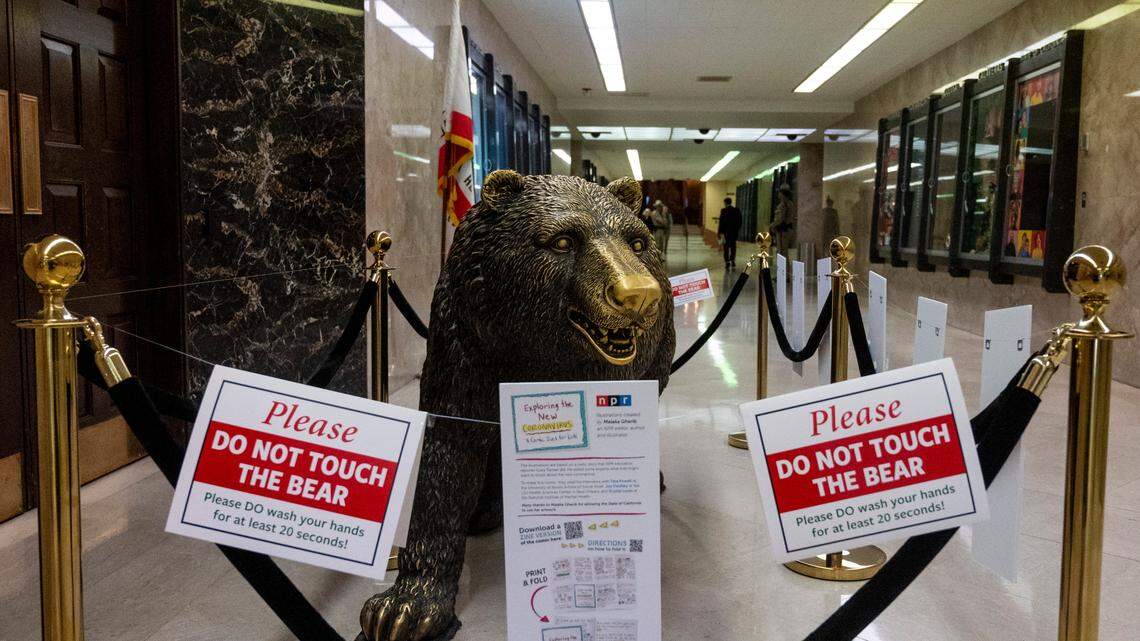 The California state bear at the entrance to the governor’s office in Sacramento warns visitors not to touch it and reminds them to wash their hands March 12 at the state Capitol. Coronavirus has shut down much of the economy and could hurt the state’s budget.