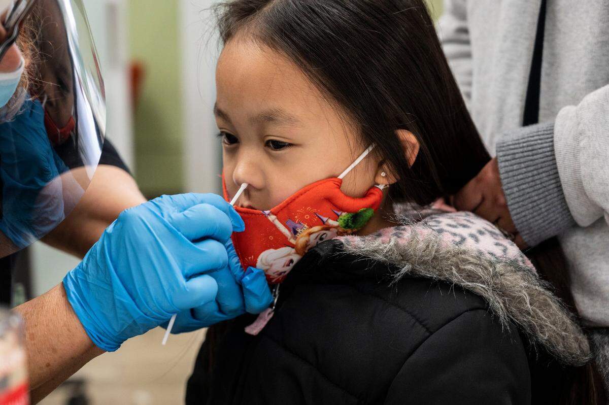 Ella Yang,5, of Sacramento receives a COVID-19 test on Monday, Jan. 3, 2022 at the La Familia Counseling Center in South Sacramento. Some people waited more than two hours in line.