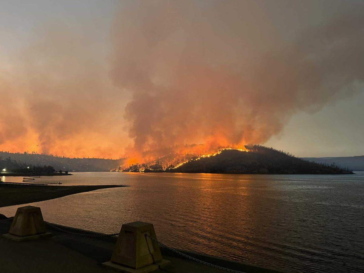 Flames are seen on the shores of Lake Oroville from the Thompson Fire on Tuesday, July 2, 2024. A suspect was arrested on suspicion of arson in connection to starting the fire, which destroyed 13 homes and forced about 13,000 people to evacuate.