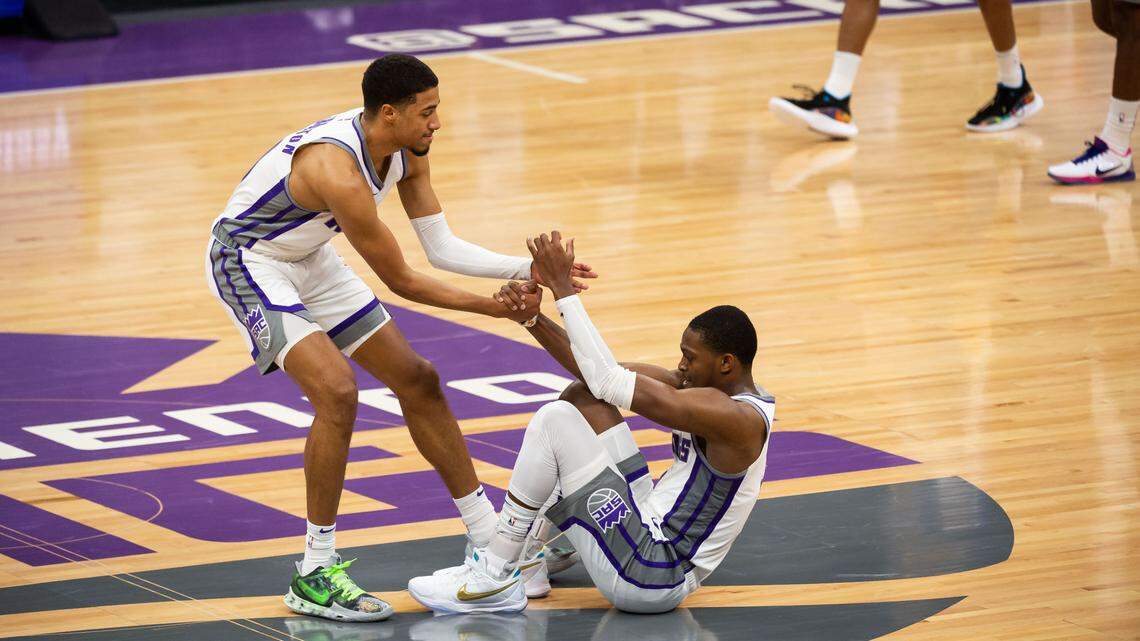 Sacramento Kings guard Tyrese Haliburton (0) helps teammate De’Aaron Fox (5) up after he was fouled by the Golden State Warriors during the second half of their final preseason game Thursday, Dec. 17, 2020, at Golden 1 Center in Sacramento. The Warriors beat the Kings 113-109.