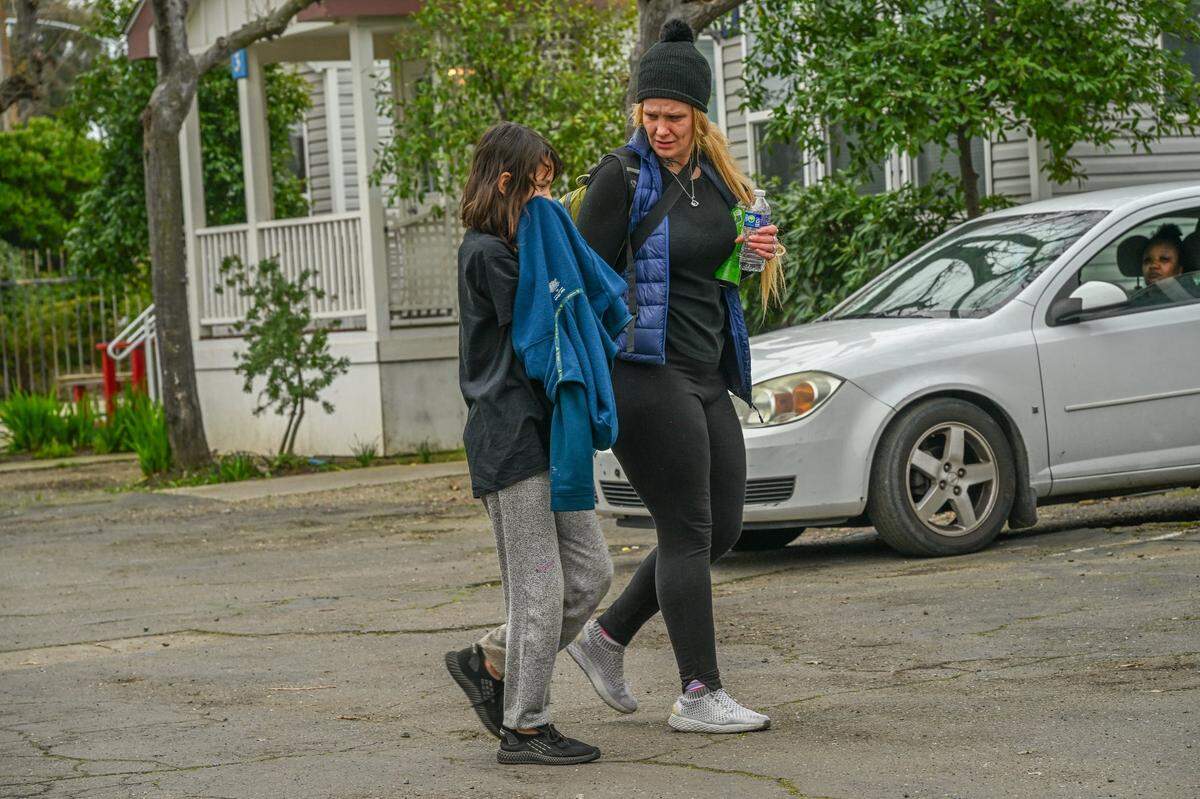 Jessica Rose walks with her daughter Faith, 11, who suffers from autism, while being evicted from a city-funded shelter in Sacramento on Feb. 16. Her daughter’s pet rabbit had been placed with some friends and Rose was worried she would not be able to get it back. She had been riding the bus daily to take her daughter to and from school. The family does not own a car so she wasn’t sure how she could get her daughter to school now.