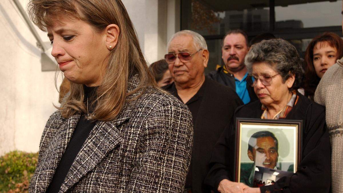 Kim Peterson, left, of the Carole Sund/Carrington Foundation speaks outside the Sacramento Sheriff’s Department on G Street in 2001 to offer a reward for information in the murder of Native American advocate Allan Olvera. Behind her stand Allan’s parents Henry, center, and Dorothy Olvera, holding a photograph of Allan.
