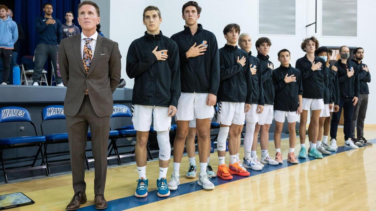 Waldorf Waves coach Dean Stark stands with his team during the playing of the national anthem before the home game against John Adams Academy on Monday, Dec. 12, 2022, at Sacramento Waldorf School in Fair Oaks. On Friday, Dec. 9, 2022, Stark won his 660th game making him the winningest coach in area history for boys or girls.