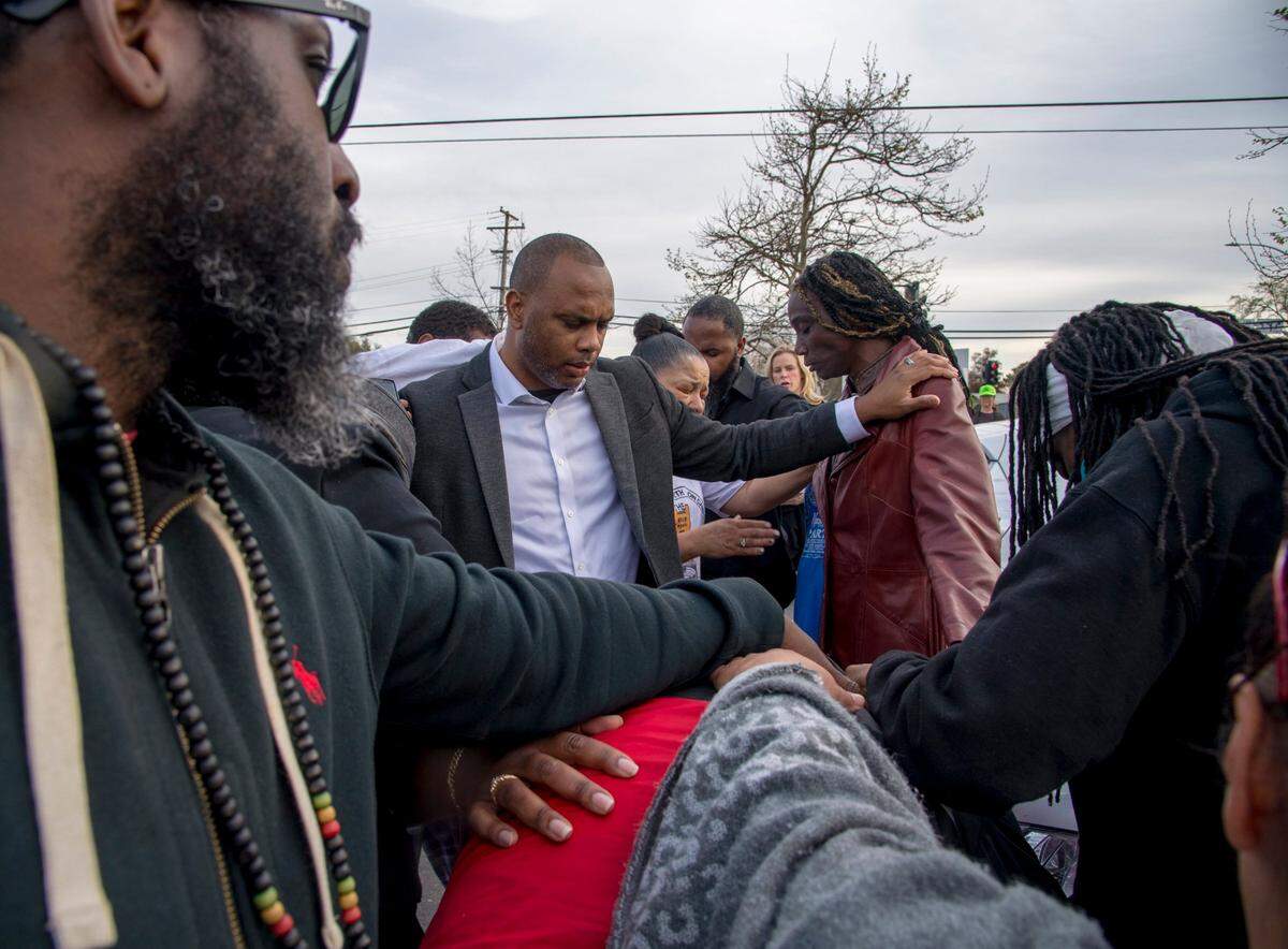 Pastor Les Simmons, center, and youth activist Barry Accius, left, pray with Sequitta Thompson, grandmother of Stephan Clark, and her family and friends in the parking lot of the Meadowview Light Rail Station on Monday, March 19, 2018, a day after Clark was killed by Sacramento police in the backyard of his grandmothers home.