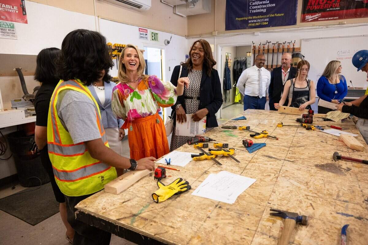 First Partner Jennifer Siebel Newsom, center, joined by Washington Unified School District Superintendent Cheryl Hildreth, laughs with students in the Career Technical Education Pathways program at River City High School in West Sacramento on Thursday.