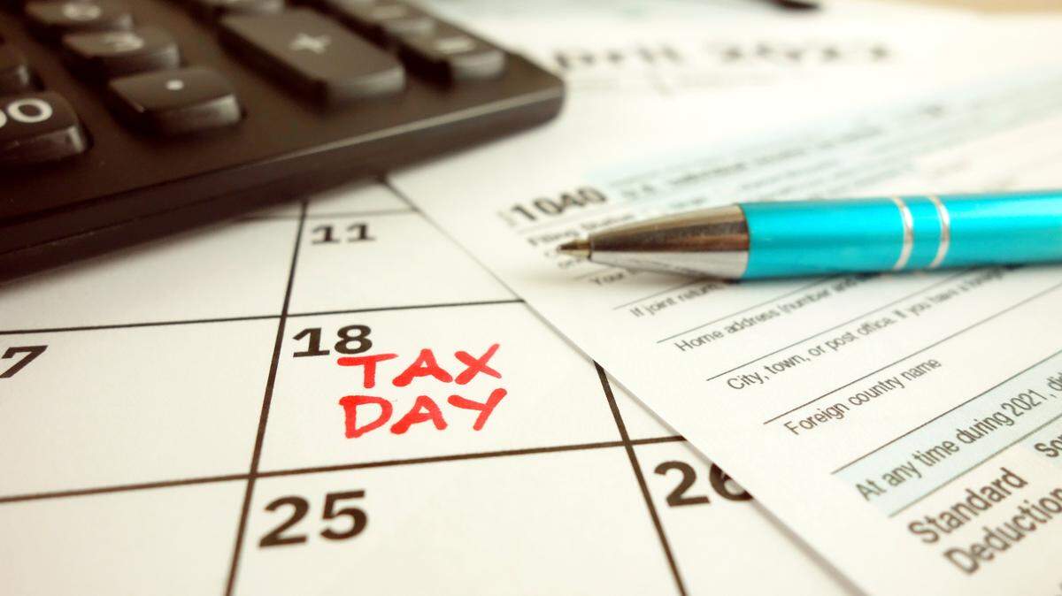Tax payment day marked on a calendar - April 18, 2022 with 1040 form, financial concept