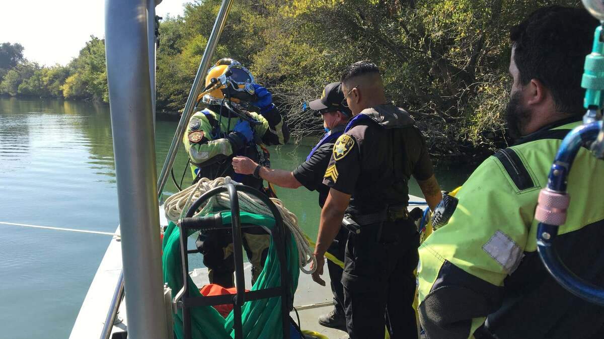 Dive and rescue teams work to locate and recover a submerged vehicle at the Sutter Slough. The body of a missing Sacramento person was found Sunday, October 11, 2020.