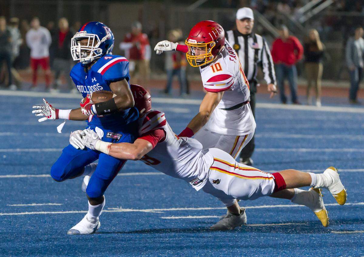 Jesuit’s Jackson Canaan, bottom, tackles Folsom’s Daniyel Ngata in the Sac-Joaquin Section Division I third-round playoff game Nov. 24, 2017.