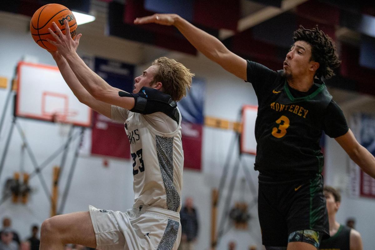The Union Mine Diamondbacks’ Nate Sweet (23) scores past the Monterey Dores’ Julian Rodriguez Johnson in the second half of the Division lV Northern California boys basketball championship game at Union Mine High School in El Dorado in March.