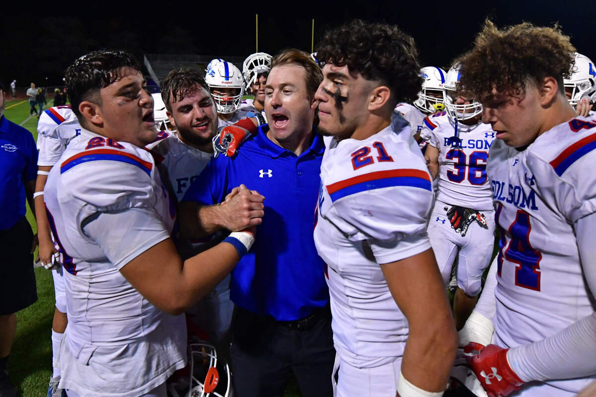 Folsom players congratulates head coach Paul Doherty after scoring a touchdown in the fourth quarter of their game at De La Salle High School in Concord on Friday, Sept. 23, 2022. Folsom defeated De La Salle 24-20.