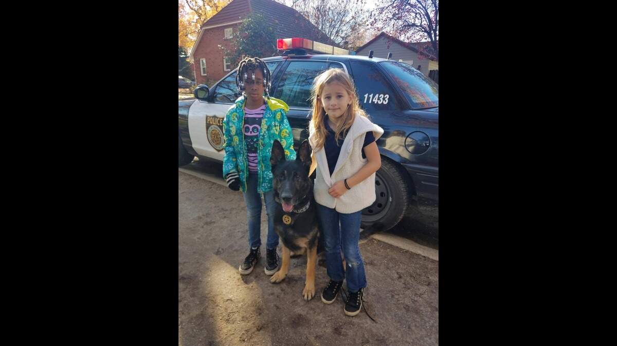 Janessa Pendarvis, left, and Ella Warren, right, pose with a police K-9, middle, after being found safe. Both 7 years old, the girls were reported missing from Peter Burnett Elementary School and found later by Sacramento police.