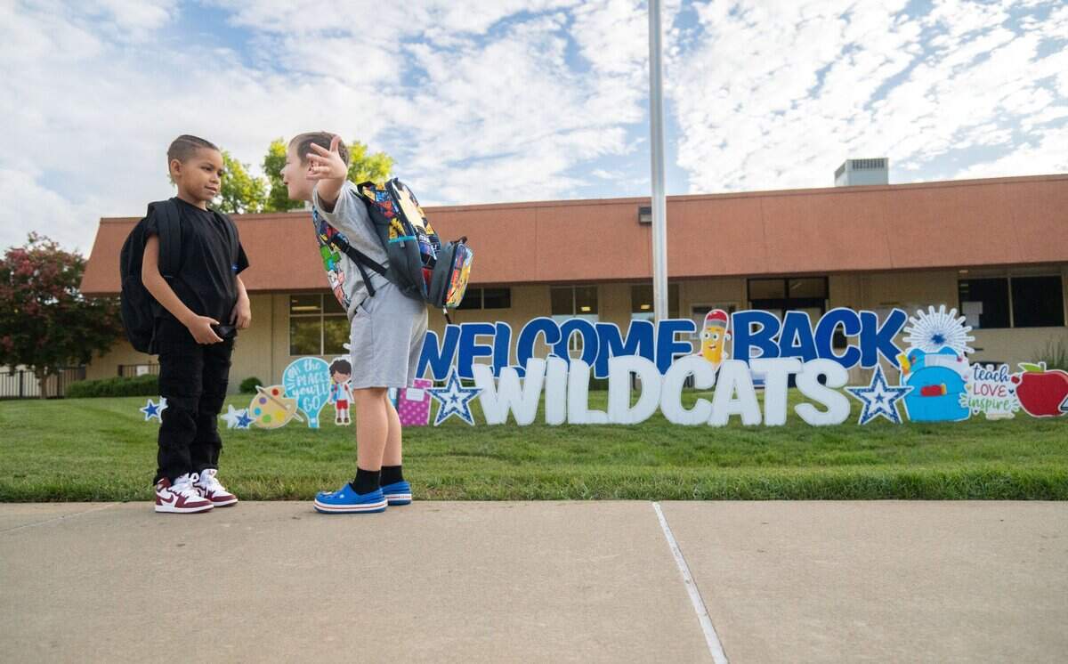 Pharoah Jennings, left, and Davis Cottrell catch up on the first day of classes at Williamson Elementary School in Rancho Cordova on Thursday, Aug. 8, 2024. “As a parent, he’s actually my fifth,” said Principal Leslee Cottrell of her son Davis, who is starting second grade. “He’s the baby.”