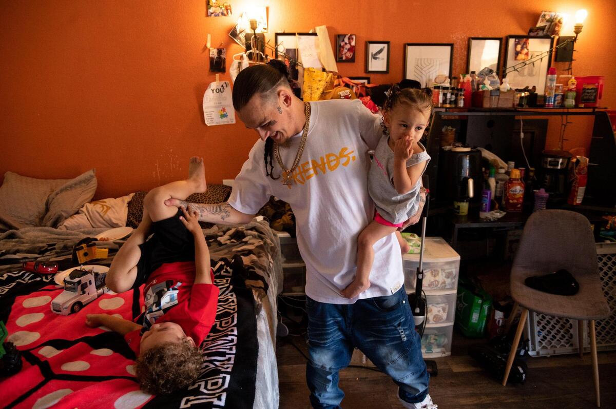 Single father Jedadiah Jincks, 27, plays with his three-year-old son Josiah and one-year-old daughter Jocelyn in their city-run motel room in Sacramento on Wednesday.
