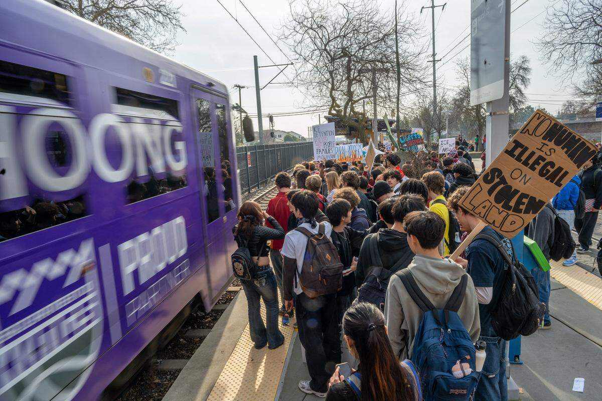 McClatchy High students wait for the next light rail train as they take part in a districtwide walkout Friday in Sacramento, part of a nationwide effort to protest immigration enforcement following fatal shootings in Minneapolis.