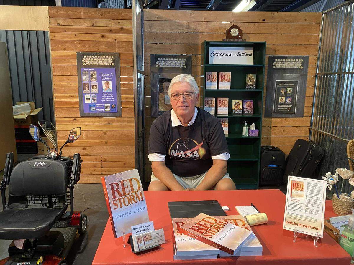 Frank Luna posing with his book at the California State Fair Authors Booth.